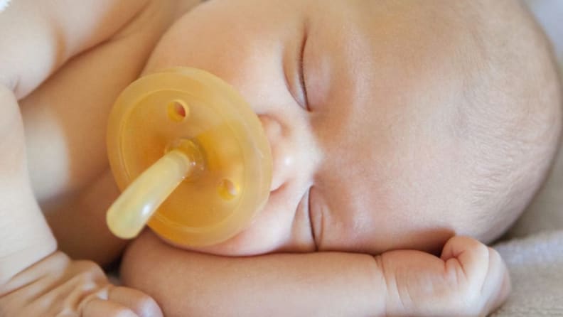 A sleeping baby with a very large Natursutten pacifier.