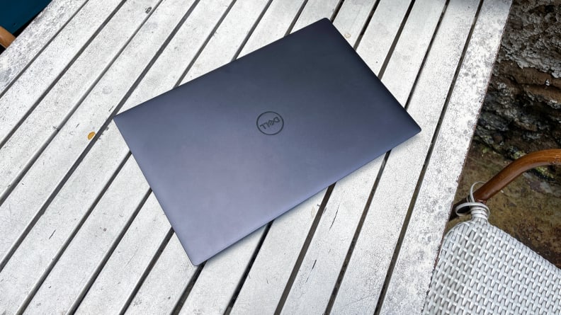 A closed Dell XPS 14 laptop on a table outdoors.