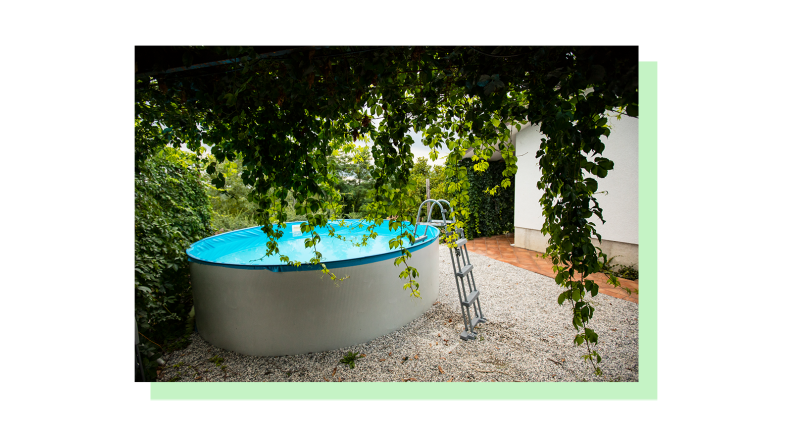 An above ground pool shown in a yard with rock landscaping.