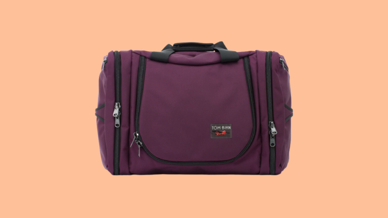 Burgundy carry-on against peach background