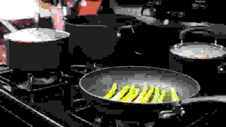 Asparagus cooking in a T-fal frying pan on a gas stove