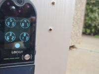 The Lockly Vision Elite keypad smart door lock with camera hangs on a front door