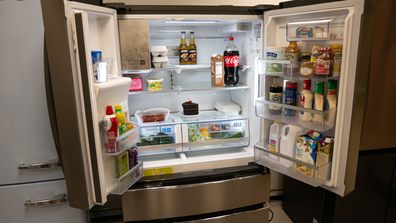 The Frigidaire doors open with a fully stocked fridge inside.