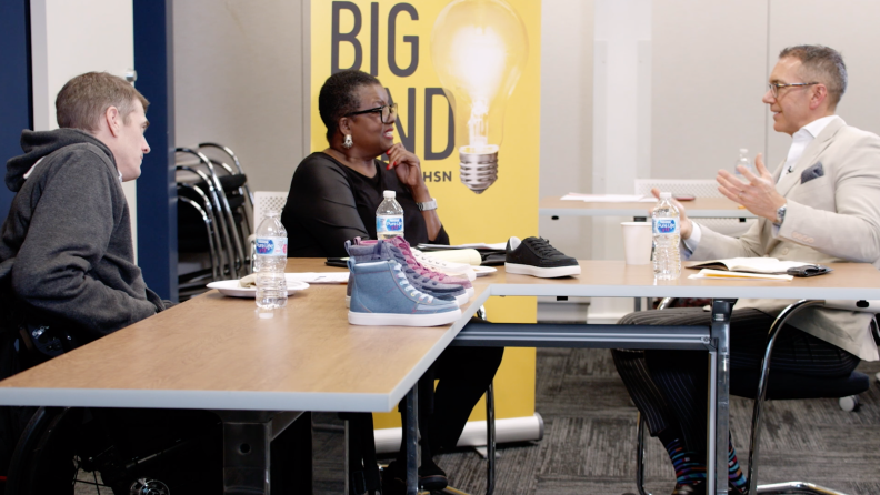 Three people having a meeting at a table.