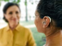 Person talking outdoors with another person outdoors.