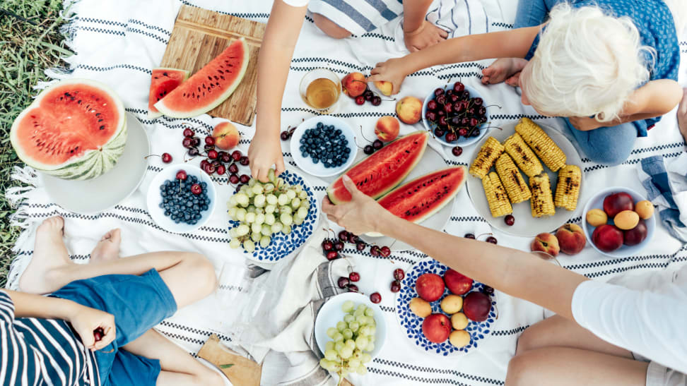 An overhead sot of a family enjoying a bountiful picnic.