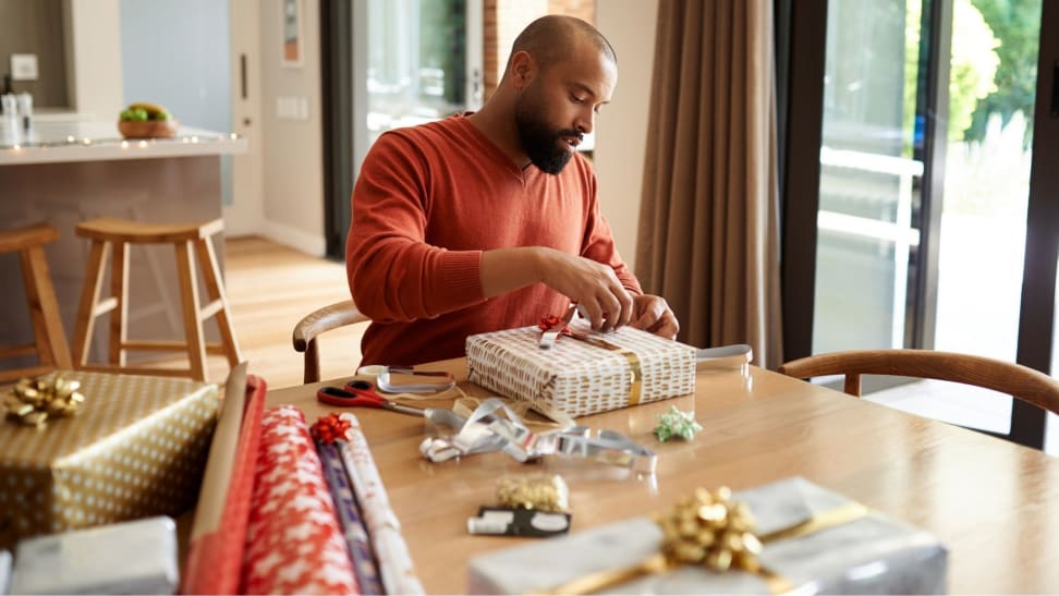 Man wrapping gifts during holiday season