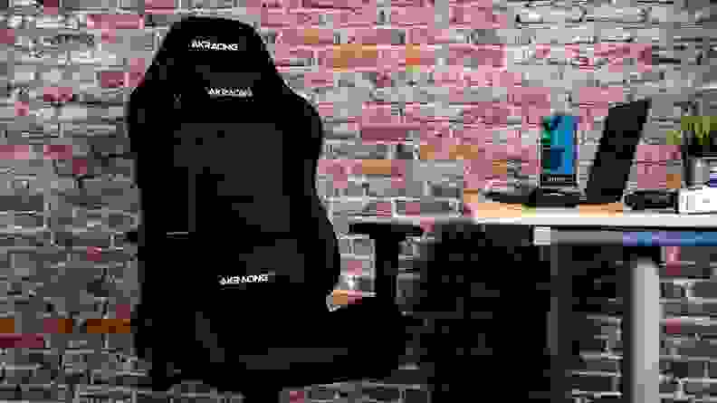 A gaming chair sits next to a desk.