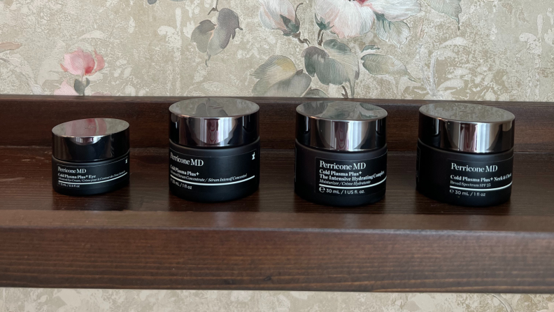 Four Perricone MD product jars lined up on a brown shelf.