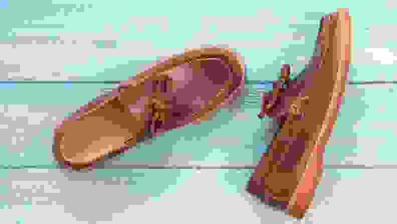 A pair of brown loafers on a blue wooden backgroud