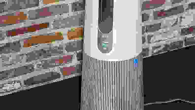 A close up of an LG PuriCare base against a brick wall.