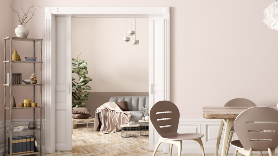 A pink dining room with a pocket door leading to a living room.