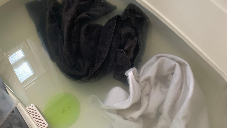 One dark towel and one light towel soaking in mixture of borax, washing soda, and laundry detergent for two hours