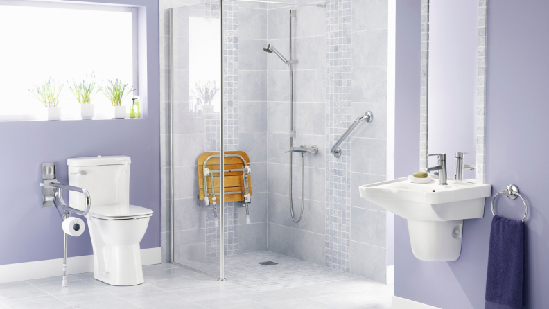 Modern bathroom with accessibly hand rails and seat in shower.