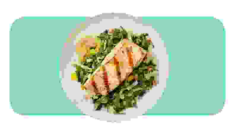 Grilled salmon served on a plate with salad.