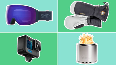 ski goggles, mittens, action camera, and fire pit on green background