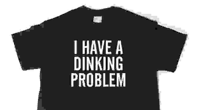 Black shirt that reads "i have a dinking problem" in white text