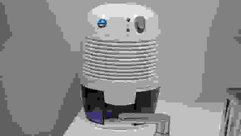 The Eva-Dry EDV-1100 small dehumidifier placed on a bathroom sink to reduce humidity in a small bathroom.