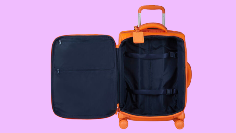 An image of a yellow carry-on luggage open to reveal the interior, which is black and contains straps and pockets.