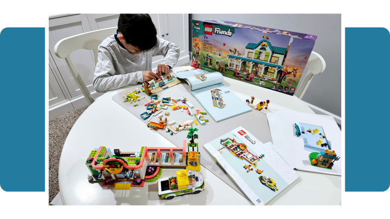 A child playing with the Lego Friends Autumn's House set.
