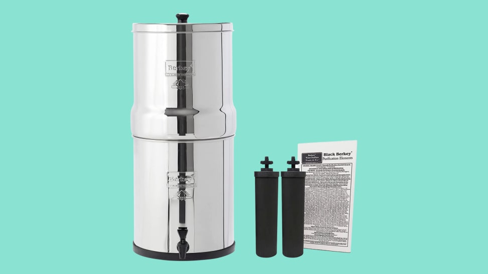 A Berkey water filter and two black filters with their packaging sit on a seafoam background.