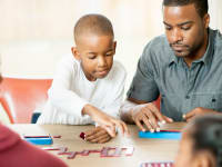 Family playing a game around the table