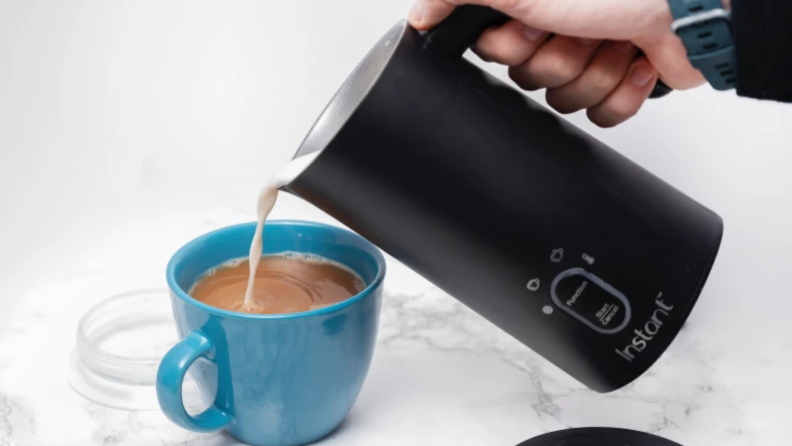 An image of a blue mug with coffee in it with foam pouring into it from a Instant