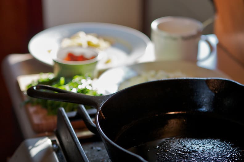 A cast-iron pan sits on a gas cooktop.