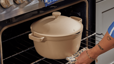 A person is pulling an oven rack, which has the Perfect Pot in gray color on it.
