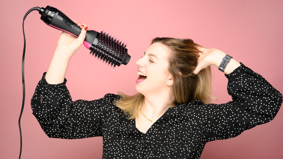 A photo of a woman pretending to use the Revlon One-Step Hair Dryer and Volumizer as a microphone.
