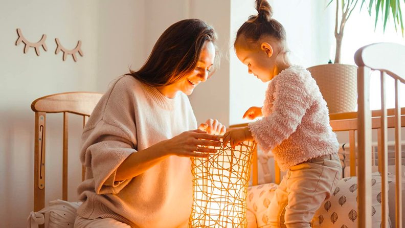 A parent and child look into a light display.