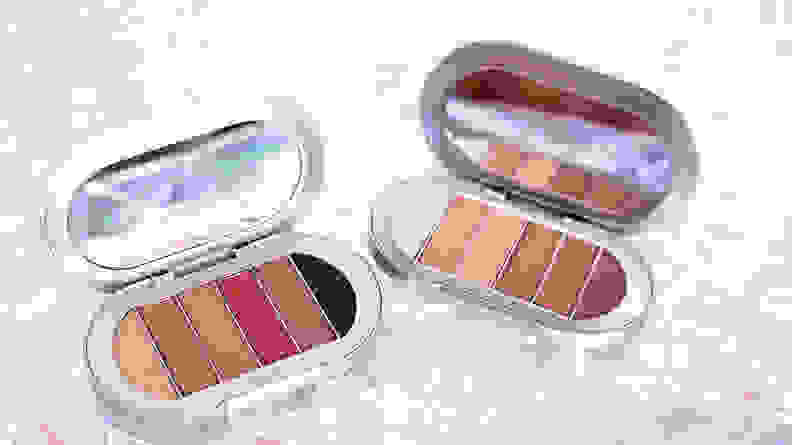 Two eyeshadow palettes open to reveal warm toned colors.