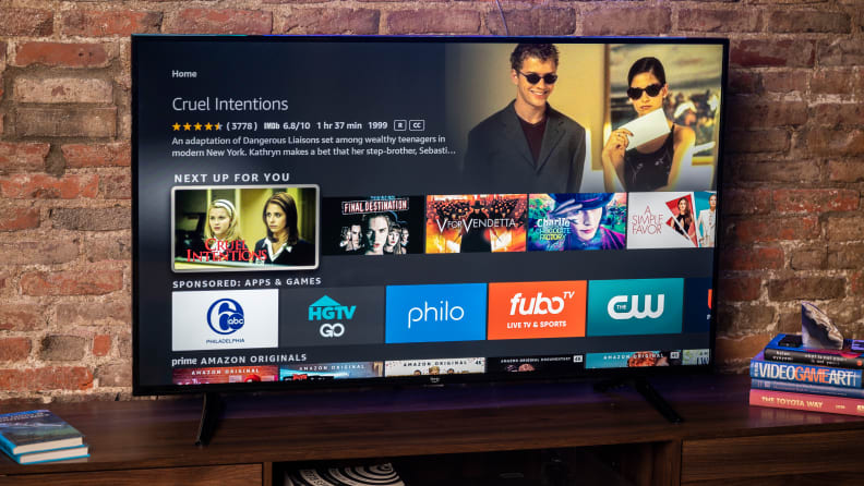 The Amazon Fire TV 4-Series displaying the home screen of its Fire TV OS smart platform in a living room setting