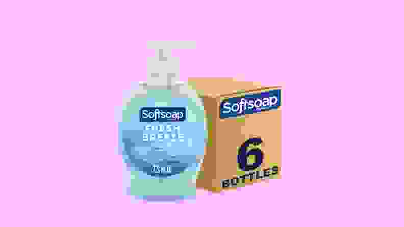 A blue container of Softsoap's Fresh Breeze liquid hand soap stands next to its brown packaging on a purple background.