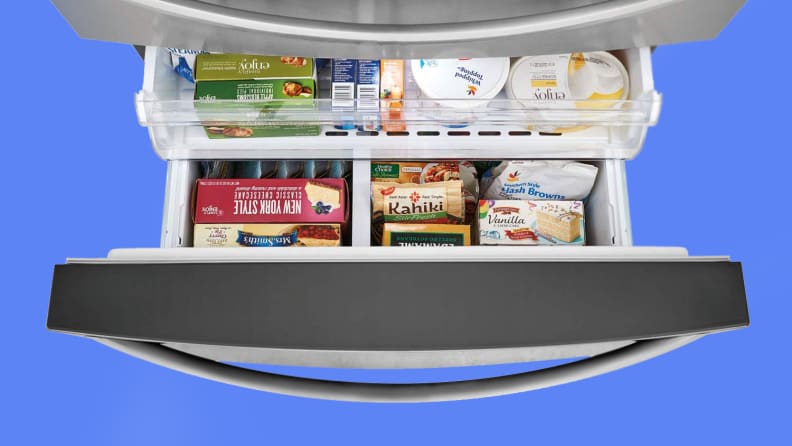 Open freezer drawer of a refrigerator showing canned frozen food.