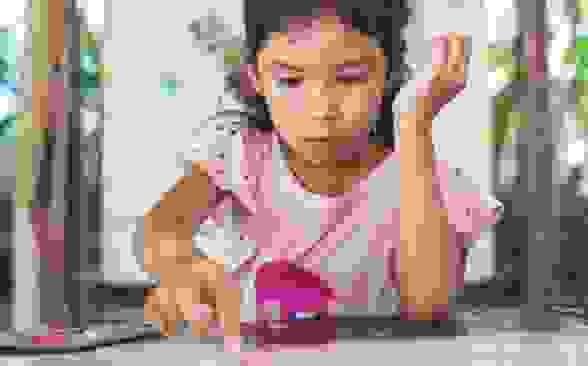 Child wearing pink shirt playing with stickers