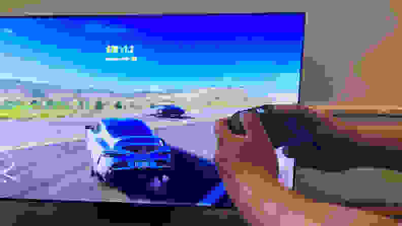 A close-up of someone's hands holding an Xbox Series X controller as they play Forza Horizon 5 via the Samsung Gaming Hub