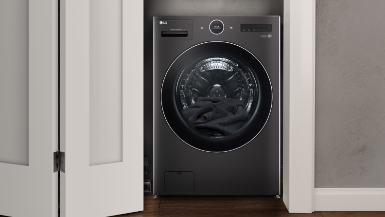 The LG Washer sits in a half-lit room next to a basket and chair.
