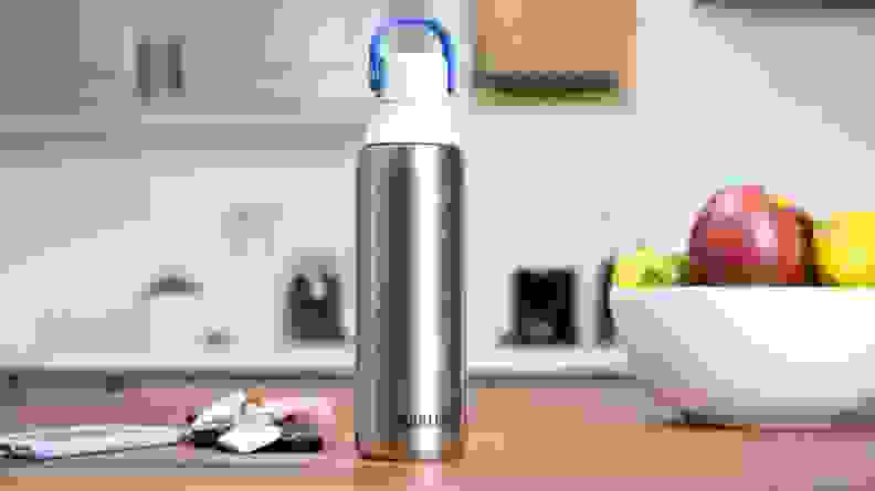 Close-up of the Brita Premium Filtering Water Bottle on a kitchen island, next to house keys and a smartphone.