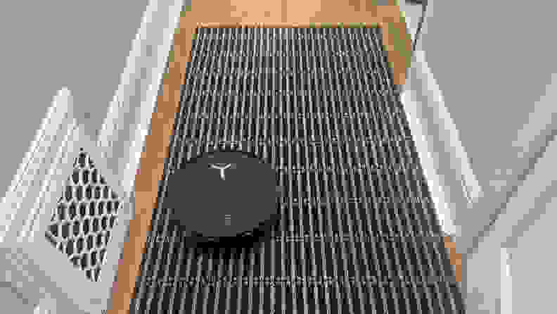 A black robot vacuum in a hallway