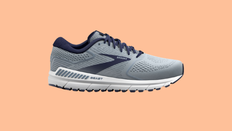 A blue and gray sneaker against an orange background.