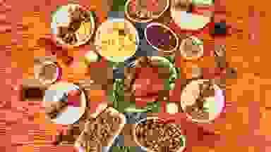 A top-down photo of a Thanksgiving feast with turkey and multiple side dishes.