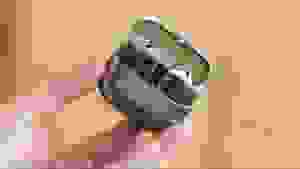 A hand holding up an open case with the earbuds inside.