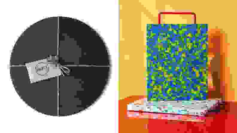 Three different cheese boards: a circular black one on the left and a pair of colorful, squared ones to the right.