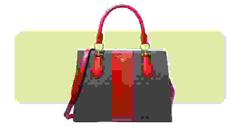 A purse made from printed coated canvas with red leather details.