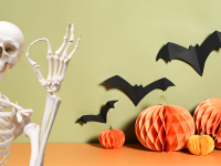 A skeleton gives the A-OK sign to some Halloween decor