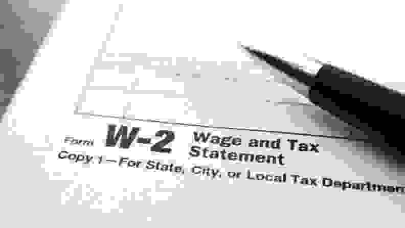 U.S. IRS W-2 tax form with a pen