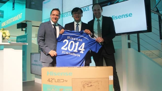 Hisense and Schalke 04 officials exchange a TV and jersey.