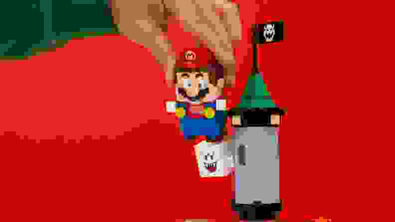 Lego Mario jumps on a Lego Boo character.