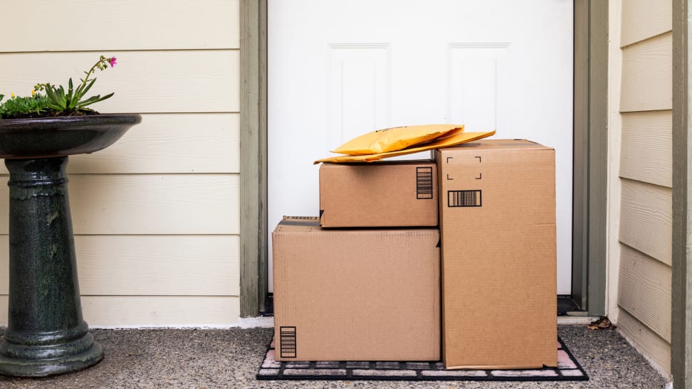 A pile of delivery boxes at the front door of a house.